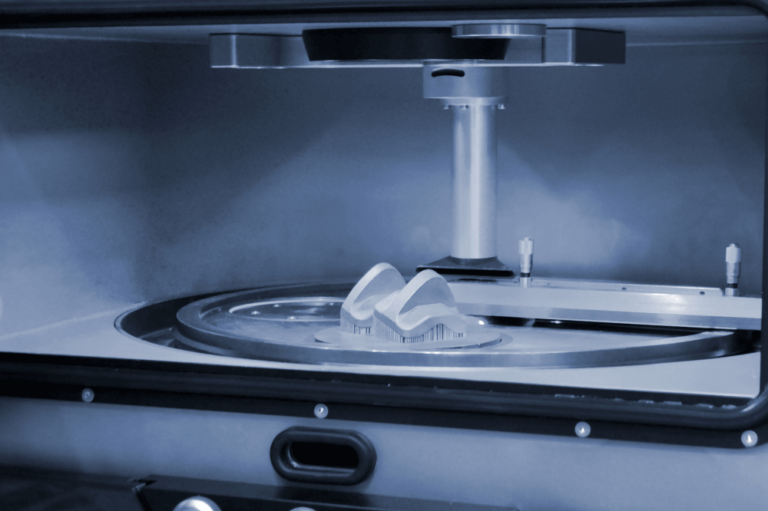 A close-up of a dental milling machine crafting a custom dental restoration, highlighting advanced dental technology.